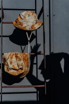 Bucket hat with rusty design, set on rusty ladder Stock Photos