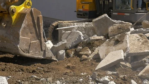 Bucket of a large excavator removing broken concrete slabs. Stock Footage 107003737