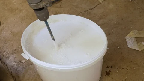 Bucket with lime paint being stirred with a stir paddle Stock Footage 71085959