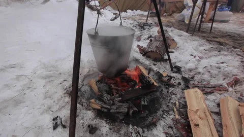 Bucket over the fire. Thick steam coming out of the bucket. Winter snow firewood Stock Footage 143704131
