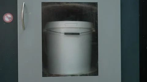 A bucket of paint quickly rotates in the automatic paint shaker Vídeos de archivo 291586926