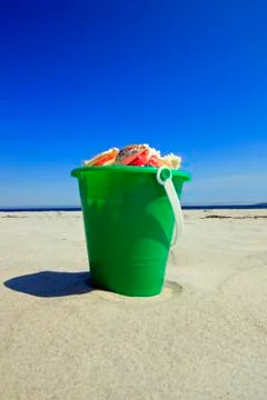 Bucket of seashells at the beach Stock Photos