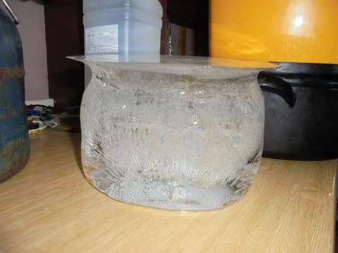 Bucket-shaped ice with crystallic structures inside standing on a kitchen unit Stock Photos