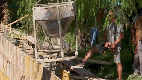 Bucket swings on a crane while delivering cement at construction site Stock Footage 118641855