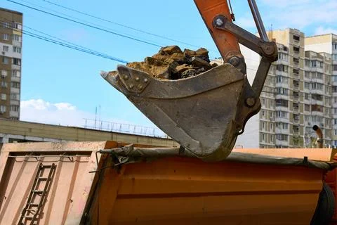 Bucket.Loading road debris with an excavator into dump truck Stock Illustration