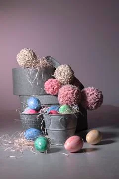 Buckets filled with easter eggs with round boxes and pompom balls Stock Photos