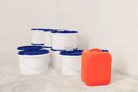 Buckets with paint and canister of primer on floor indoors Stock Photos