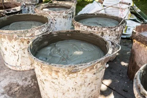 Buckets with solution of building glue for wall plastering, foam insulation Stock Photos