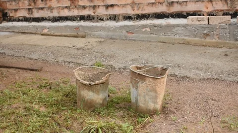 Buckets in which they wore concrete, against the wall Stock Footage 118904015