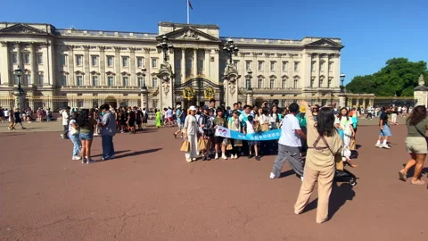 Buckingham Palace with large groups of asian visitors in London Stock Footage 321685964