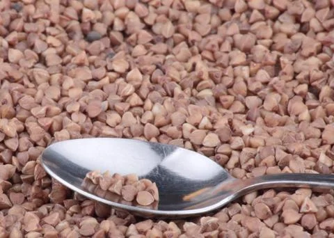 Buckwheat background and teaspoon Stock Photos