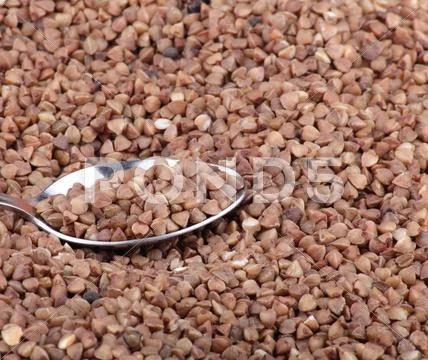 Buckwheat background and teaspoon Stock Photos