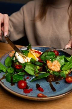 Buckwheat bread toasts with a poached egg, a sliced avocado, a shrimps, tomat Stock Photos