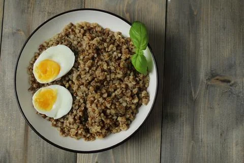 Buckwheat, chicken egg, basil on a gray background with space for copyspace.. Stock Photos