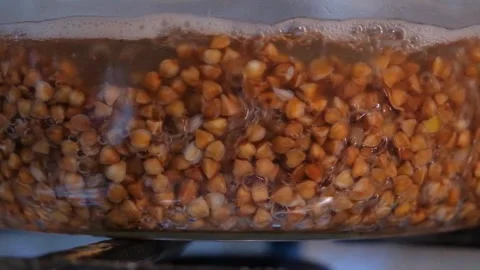 Buckwheat cooking process. Buckwheat is cooked in a transparent glass pan. Cooki Stock Footage 283630109