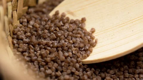 Buckwheat couscous grains falling on a bamboo spoon Vidéo 280388607
