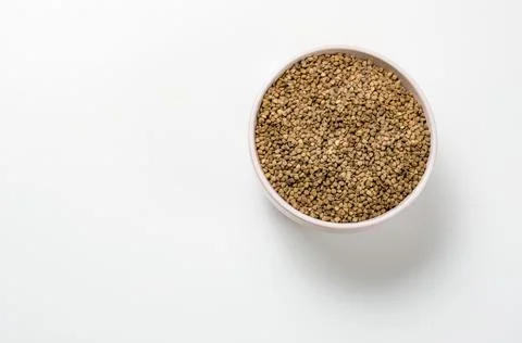 Buckwheat in a deep plate on a white background. Stock Photos