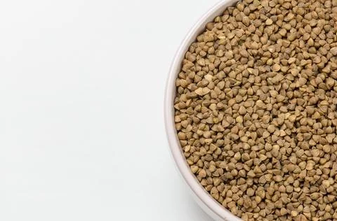 Buckwheat in a deep plate on a white background. Stock Photos