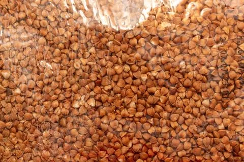 Buckwheat grains in transparent plastic packaging for food storage and sale Stock Photos