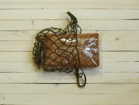 Buckwheat Packed in a string bag on a light wooden background Stock Photos