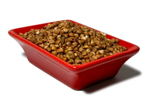 Buckwheat in a red rectangular saucer isolated on white background. Close-up Stock Photos