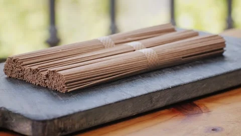 Buckwheat soba pasta on a black texture background.Raw thai noodles and Stock Footage 286359423
