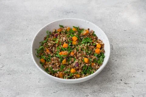 Buckwheat with vegetables and kale on a gray textured background, top view... Stock-Fotos