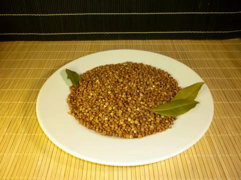 Buckwheat in a white plate with a laurel leaf Stock Photos