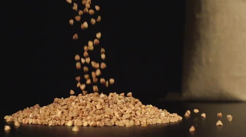 A buckwheats fall in a pile on a table near a bag Stock-Footage 59019830