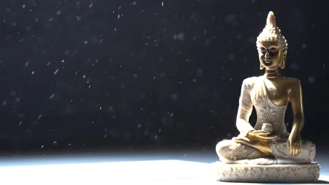 Buddha meditating during winter snowfall Stock Footage 119689301