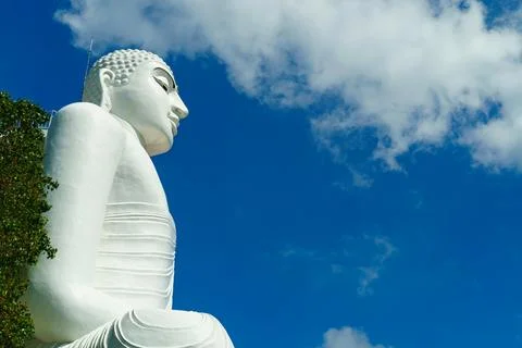 Buddha in profile against a sky with clouds Stock Photos