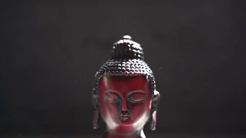 Buddha red Idol face close up with black background Stock Footage 136593032