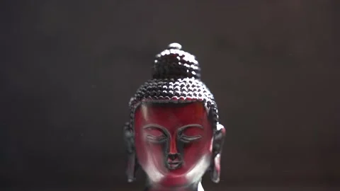 Buddha red Idol face close up with black background Stock Footage 136593974
