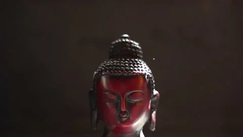 Buddha red Idol face close up with black background Stock Footage 136594127