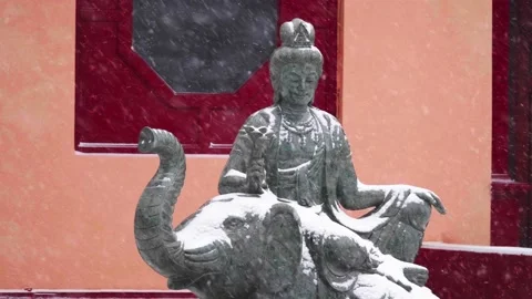 Buddha Sitting on a Elephant Statue in Snowfall Stock Footage 232377858