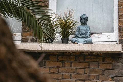Buddha Statue with Greenery surrounded by plants Stock Photos