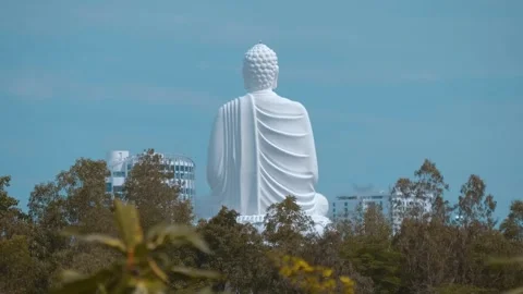 Buddha statue, known as Kim Than Phat To rises above the trees and buildings Stock Footage 340457501