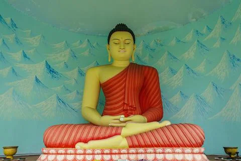 Buddha statue in red clothes sitting Stock Photos