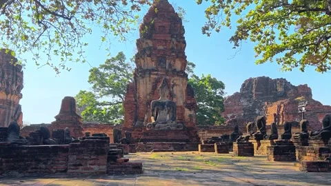 Buddha statue sits within the crumbling red brick ruins of ancient temple. Stock Footage 306770738