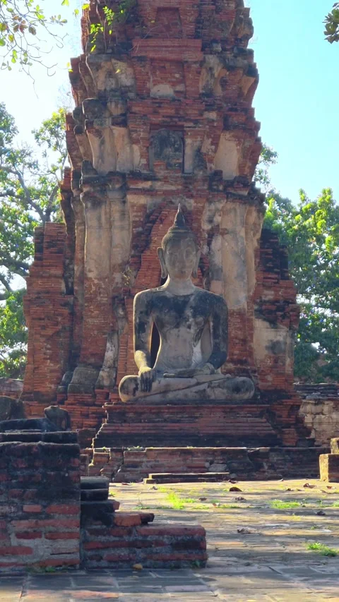 Buddha statue sits within the crumbling red brick ruins of ancient temple. Video stock 309466227