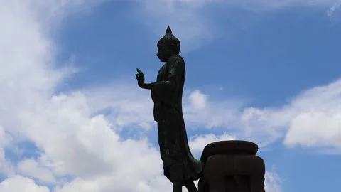 Buddha statue is standing isolated on blue sky and white cloud Stock Footage 139905426