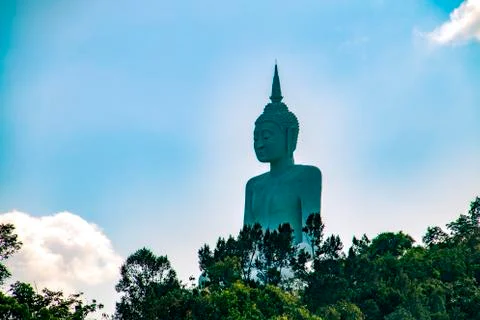 Buddha statue on a sunny day against the background of green tropical forest Stock Photos