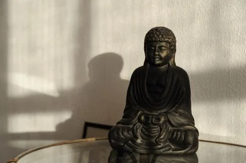 Buddha statuette on the table. Stock Photos