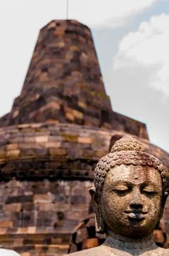 Buddha stone sculpure sitting in front of stupa Stock Photos