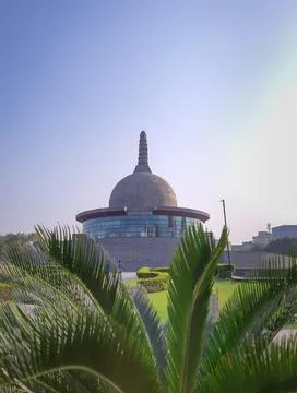 Buddha stupa through leafs with bright sky at morning from low angle Fotos de archivo