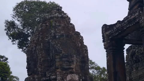 Buddha's faces engraved in stone on the pillar roof of a Bayon Temple in Siem  Stock Footage 305672531