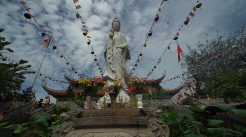 Buddha's statue is located on the background of Buddhist temple in cloudy summer Stock Footage 67426061