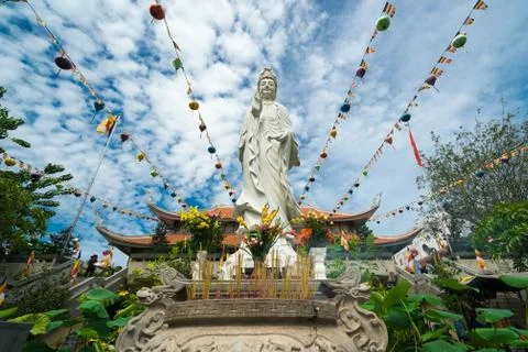 Buddha's statue is located on the background of Buddhist temple in cloudy s.. Stock Photos
