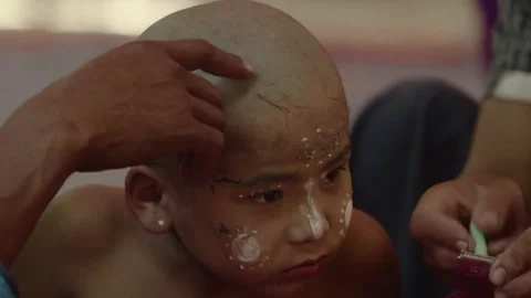 Buddhist boy undergoing a head shaving ritual in Myanmar 스톡 동영상 332758223