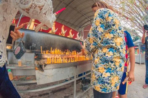Buddhist devotee lighting a stick with a candle at Hat Yai Municipal Park. Stock Photos